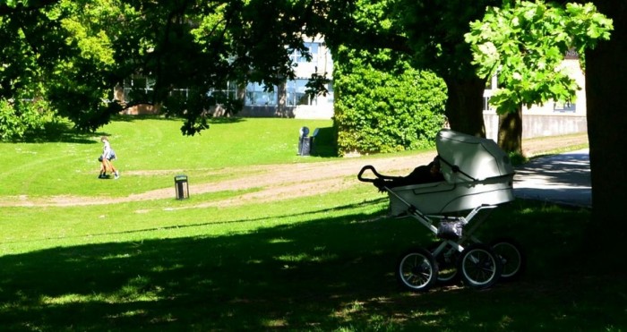 Carrinho de bebê repousa debaixo de árvore em parque de Aarhus (Dinamarca)